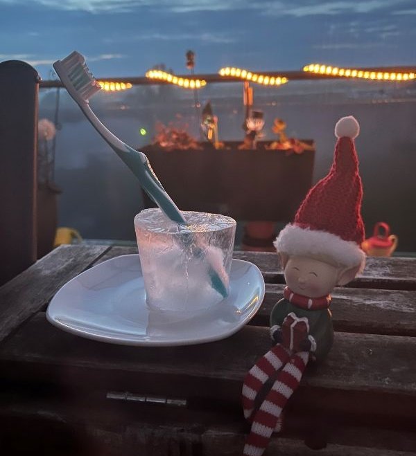 Wichtel auf Balkon im Winter in Wittenberg mit gefrorener Zahnbürste im Glas 