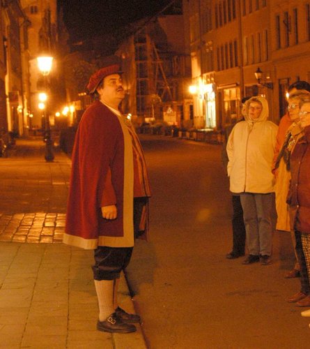 Gewandeter Stadtführer bei Nacht