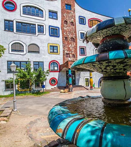 Brunnen mit Hundertwasserschule im Hintergrund
