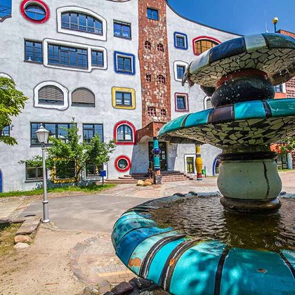 Brunnen mit Hundertwasserschule im Hintergrund