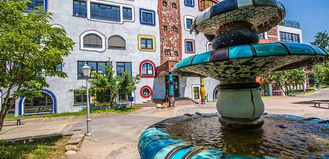 Brunnen mit Hundertwasserschule im Hintergrund