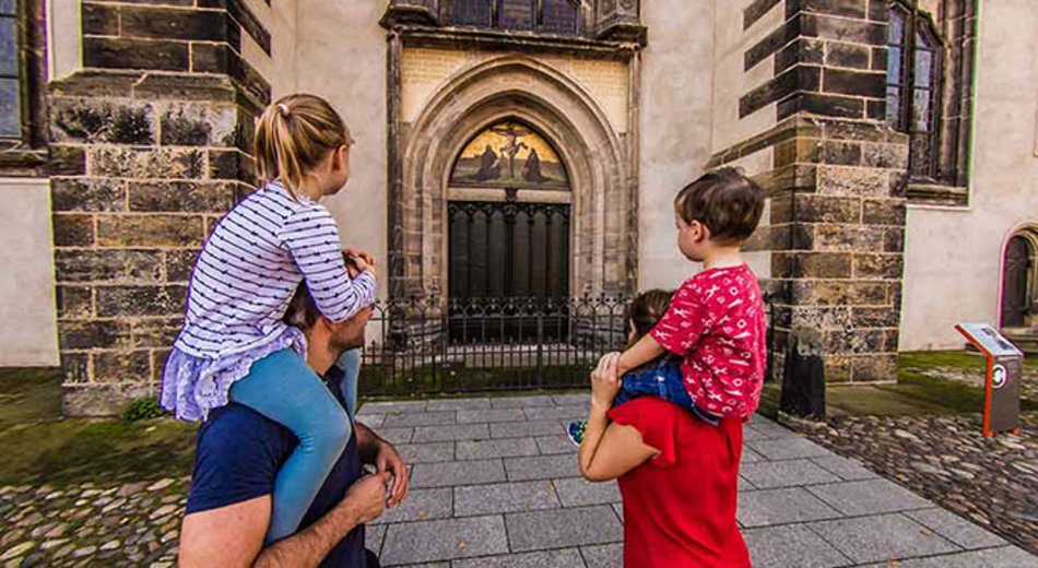 Familie mit kleinen Kindern an der Schlosskirche Wittenberg